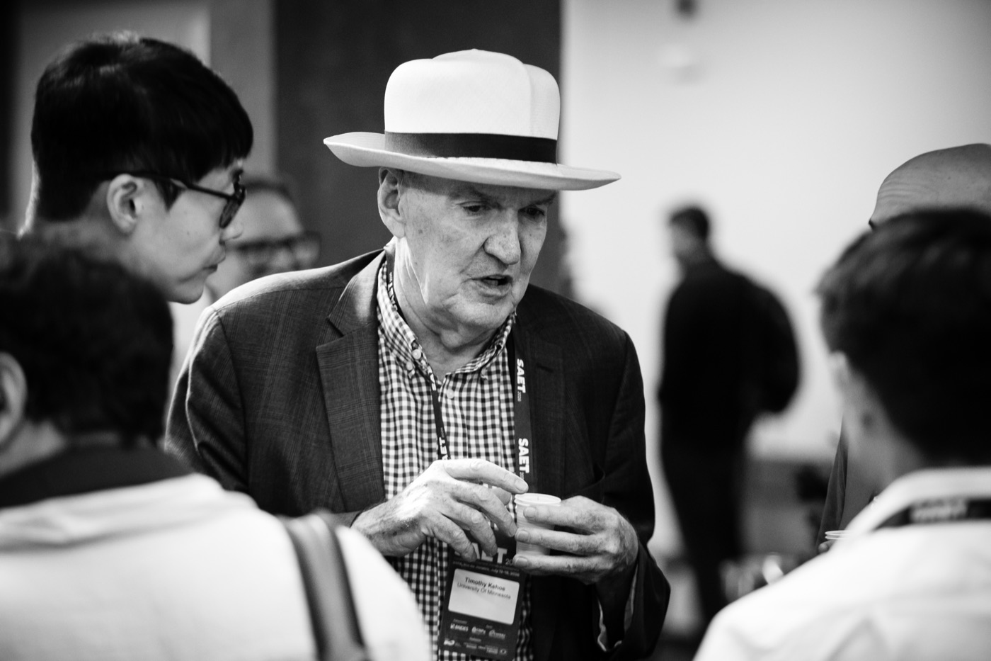 Timothy Kehoe in a panama hat talking with Sewon Hur at the SAET conference